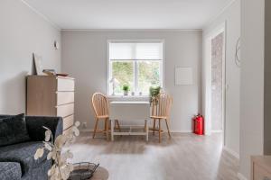 ein Wohnzimmer mit einem Tisch, Stühlen und einem Fenster in der Unterkunft Nice cottage outside Hassleholm in Hässleholm