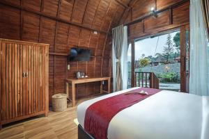 a bedroom with a bed and a large window at Navalia Villa Bedugul in Bedugul
