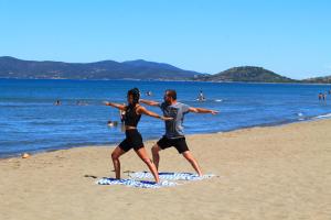 dos personas de pie en una toalla en la playa en Argentario Osa Resort, en Talamone
