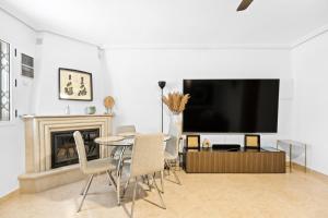 a living room with a table and a tv at Casa Plugge in Torrevieja