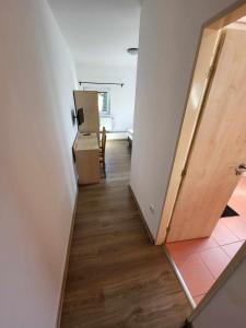 pusty korytarz z pokojem z drzwiami i drewnianą podłogą w obiekcie Restaurace a penzion Vrtule w mieście Pietwałd