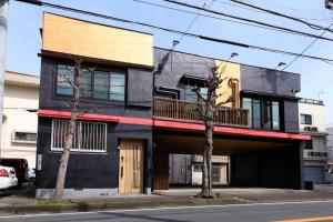 un edificio nero con balcone su strada di Mahana Ito a Ito