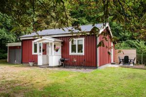 a red shed with chairs in a yard at Nice cottage outside Hassleholm in Hässleholm