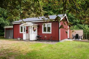 czerwona szopa z krzesłami na dziedzińcu w obiekcie Nice cottage outside Hassleholm w mieście Hässleholm