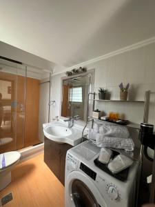 un bagno con lavatrice e lavandino di Elegant Escapes 4 ad Atene