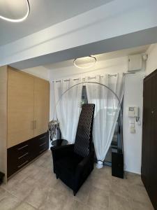 un soggiorno con una sedia e una finestra di Elegant Escapes 4 ad Atene Altre 2 foto