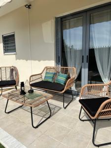 trzy wiklinowe krzesła i stół na patio w obiekcie Elegant Escapes 4 w Atenach