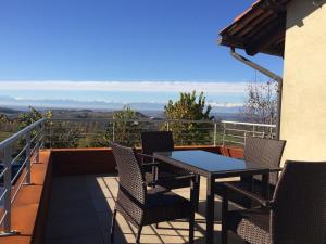 a patio with a table and chairs on a balcony at Casa Montagliato in Monforte dʼAlba