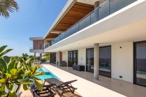 - une vue extérieure sur une maison avec une piscine dans l'établissement Luxury 12-Person Villa in Cas Abou with Pool, Seaview, and Private Beach Access, à Willibrordus