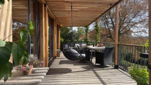 a wooden porch with a table and a swing at My Happy Box in Ochsenfurt