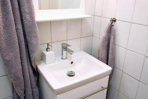 uma casa de banho com um lavatório branco e um espelho. em Bude 1: Liebevoll saniert & komfortabel em Kiel