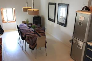 ein Esszimmer mit Tisch und Kühlschrank in der Unterkunft São Vicente House in Lissabon