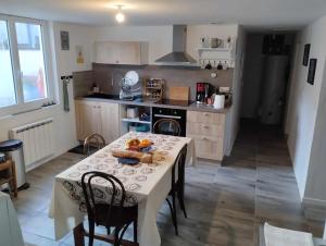 a kitchen with a table with a bowl of fruit on it at Maison rénovée in Millières