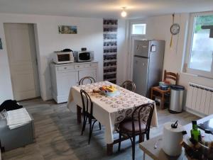 a small kitchen with a table and a refrigerator at Maison rénovée in Millières