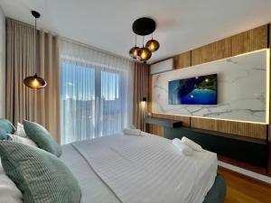 een slaapkamer met een groot bed en een tv aan de muur bij Boma Central in Boekarest