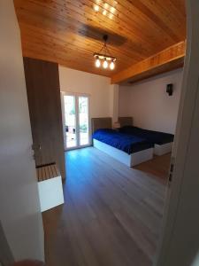 a bedroom with two beds and a wooden ceiling at Bujtina Lugina e vjosës in Përmet