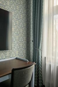 a desk with a chair next to a window at Roze Peldu Residence in Liepāja