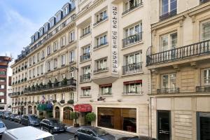 a large building with cars parked in front of it at Hotel Etats Unis Opera in Paris