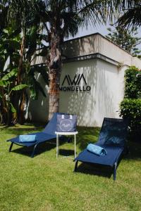 蒙德羅的住宿－AWA Mondello，大楼前的两把椅子和一张桌子