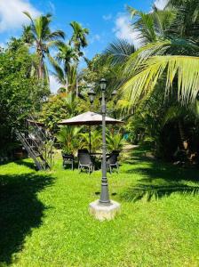 a lamp post in the grass with chairs and an umbrella at Manik Villa in Bentota