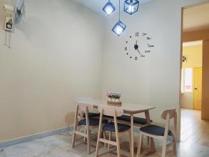 uma sala de jantar com uma mesa e um relógio na parede em Kapar Nala 50 Double storey3 Rooms 1-6 pax em Kapar