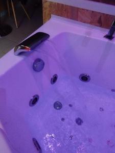 una bañera púrpura con un cuchillo. en Gîte Sauna Balnéo Berck sur Mer Lâchez Prise en Berck-sur-Mer