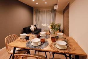 a dining room table with bowls and plates on it at Pacific Coast Enoshima by Tranova in Fujisawa
