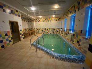 a large swimming pool in a room with colorful tiles at Tisa Hotel in Kyiv