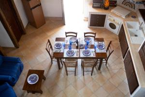 een keuken met een tafel en stoelen met borden erop bij Villa Alessandro in Castellammare del Golfo