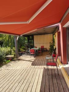 a wooden deck with chairs and a table and an umbrella at villa Padivier in Saint-Point-Lac