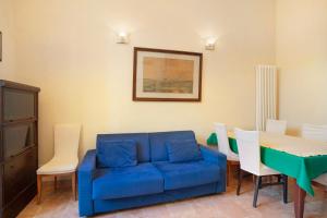 a living room with a blue couch and a table and chairs at Ferrovia, borgo dei pescatori in Cervo