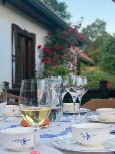 a table with glasses of white wine on it at Bohemian forest paradise 