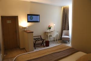 una camera d'albergo con un letto, una sedia e un tavolo di Hôtel Moderna a Cherbourg en Cotentin