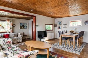 sala de estar con mesa y comedor en Cottage with its own sandy beach near Vimmerby, en Vimmerby