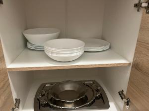 une cuisine avec des assiettes et des bols sur une étagère dans l'établissement Orlando apartman, à Kotor