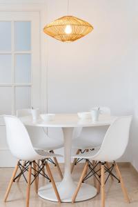 een witte eetkamer met een witte tafel en witte stoelen bij Magno Apartments Alfarería - Private Parking included in Sevilla