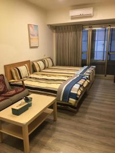 ein Hotelzimmer mit 2 Betten und einem Sofa in der Unterkunft 果芒驛站旅店 in Taipeh