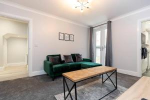 a living room with a green couch and a table at Modern 2 BR perfect for family friends and workers in South Shields