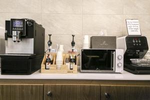 a counter with a microwave and a coffee maker at Aden Hotel in Cheonan +31 photos