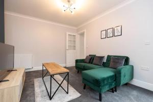 - un salon avec un canapé vert et une table dans l'établissement Modern 2 BR perfect for family friends and workers, à South Shields