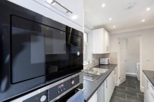 a kitchen with a large black microwave above a counter at Modern 2 BR perfect for family friends and workers in South Shields