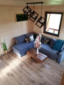 a living room with a blue couch and a table at Domki OstoYa Bieszczady/Solina in Myczkowce