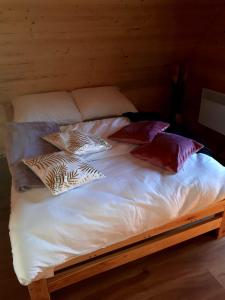 a bed with white sheets and pillows on it at Domki OstoYa Bieszczady/Solina in Myczkowce