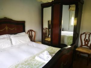 1 dormitorio con 1 cama con 2 sillas y espejo en Vixía do Val Classic, en Pontevedra