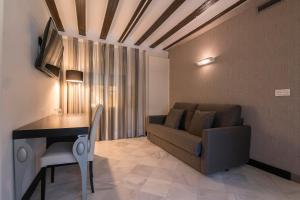 a living room with a couch and a table at Hotel Palacio Marqués de Arizón in Sanlúcar de Barrameda