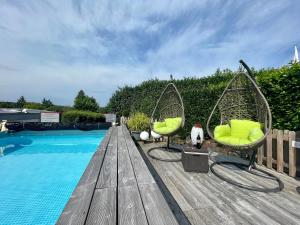 zwei Stühle auf einer Holzterrasse neben einem Pool in der Unterkunft Schöne helle Ferienwohnung 35606 Solms Lahn Küche separat in Braunfels