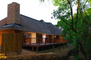 a house with a large deck in the woods at Kruger Park Lodge Unit 268 - PMP in Hazyview