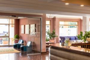 a lobby with blue chairs and a living room at Park Hotel Residence in Orbetello