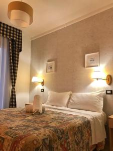 una camera d'albergo con un grande letto con cuscini bianchi di Hotel Riviera a Lido di Jesolo