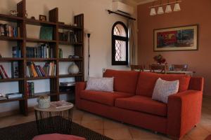 a living room with a red couch and book shelves at Panmar in Vasilikos